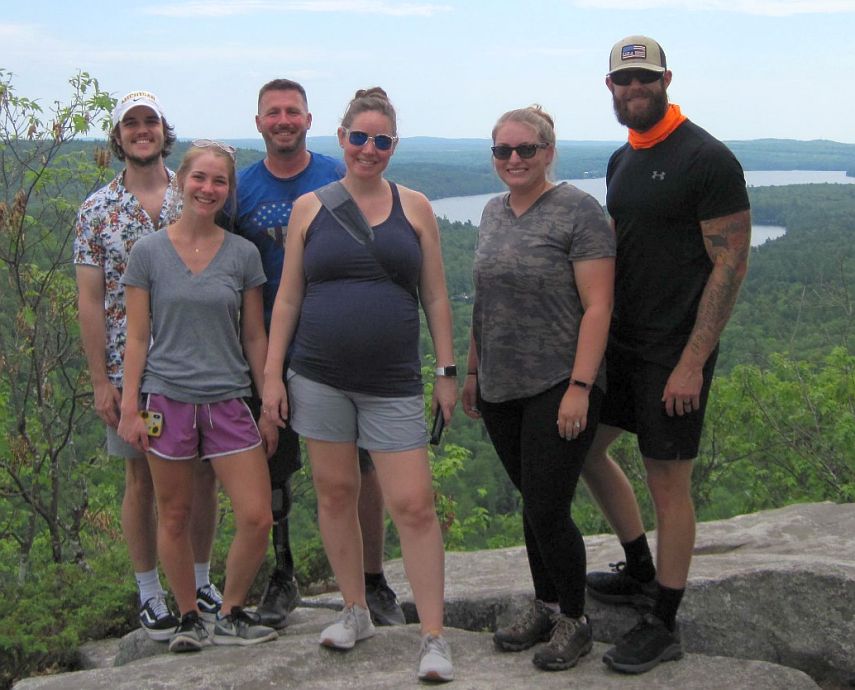 A veteran and his family, with staff from the Travis Mills Foundation, on top of French Mountain.