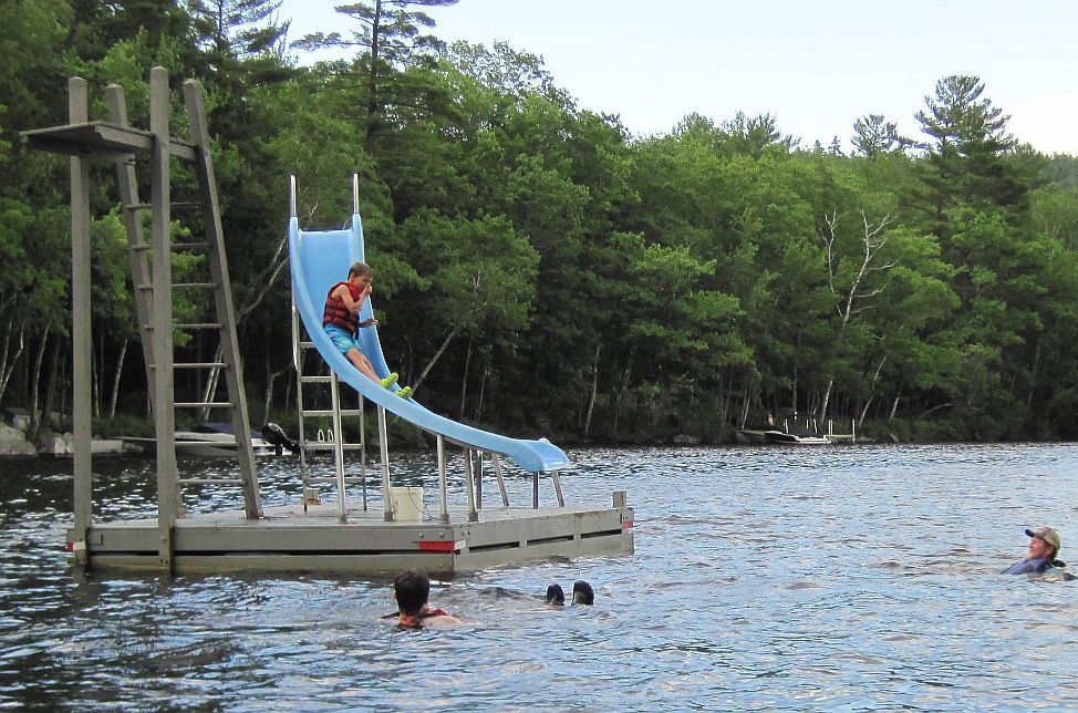 Jason Toner (on the far right in the water and wearing a hat) waits for one of his nephews to come down the slide.