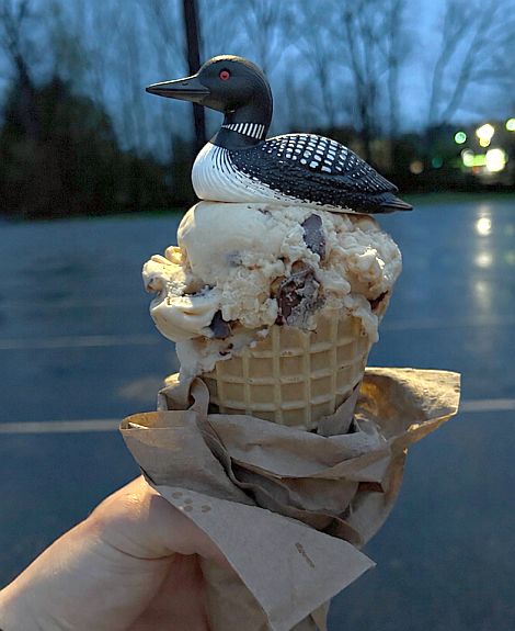 An ice cream cone topped with a plastic(?) loon.