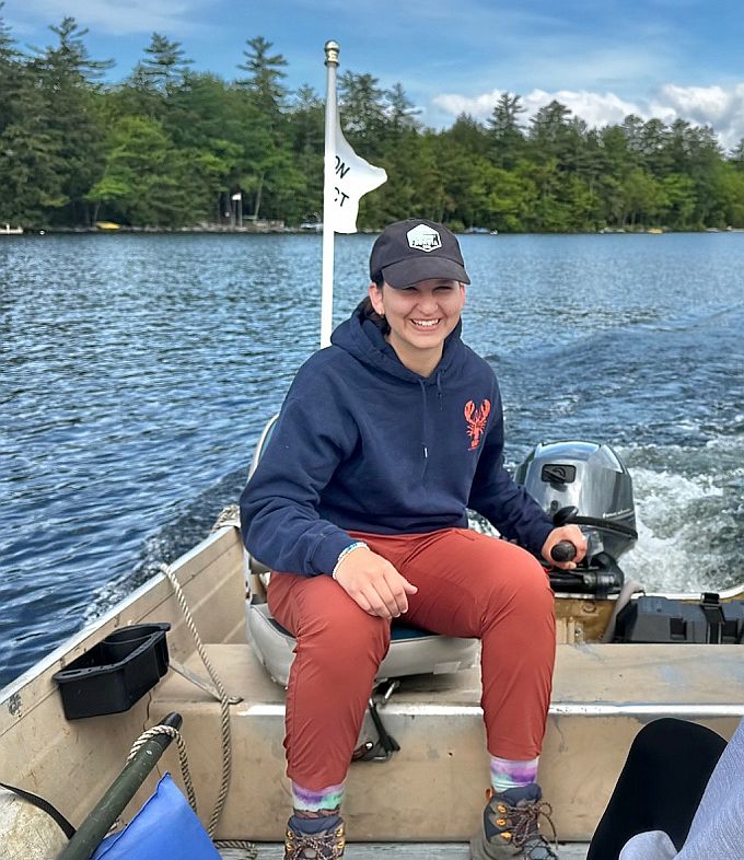 2026 Colby Loon Intern Katie Lutz at the helm of the Loon Project boat.